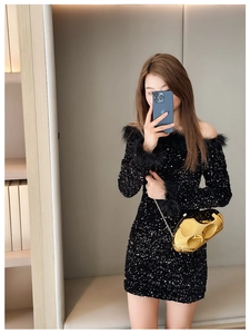 Detail of a sparkling black sequin mini dress with luxurious feather trim on the sleeves