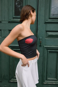 Detailed view of black strapless tube top featuring a vibrant red rose print