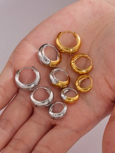 Détail macro de boucles d'oreilles créoles épaisses bicolores en acier poli, quatre tailles
