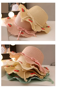 Close-up of girls straw hats with cherry embroidery and wavy edges in multiple colors