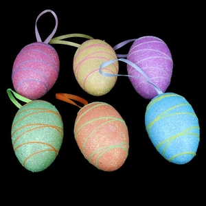 Detail of colorful glittery Easter hanging eggs in pink yellow purple and green