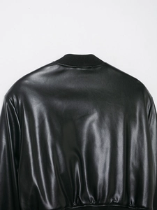 Detail of black faux leather flight jacket showing ribbed knit collar and back texture