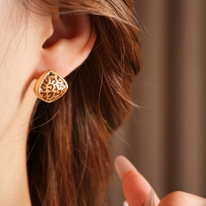 Gros plan de boucles d'oreilles léopard sur modèle avec finition dorée rétro