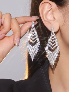 Close-up of elegant silver tassel earrings with sparkling rhinestones on model