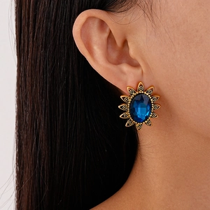 Detailaufnahme von Vintage-Sonnenblumen-Ohrstecker mit blauem Stein am Ohr getragen