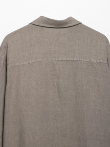 Detailed close-up showing the natural linen texture and stitching of the gray-brown shirt