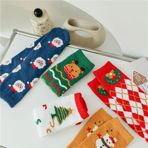 Close-up of thick coral fleece Christmas socks featuring soft reindeer and santa patterns