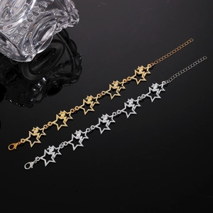 Détail de bracelets à breloques en forme d'étoile creuse en or et argent avec fermoir mousqueton