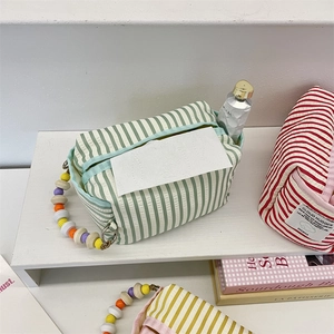 Detailed macro of a striped fabric tissue box with colorful wooden beads and brand label