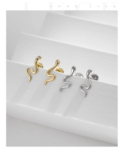 Macro shot of S925 sterling silver snake earrings with crystals on a white display