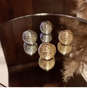 Detailed macro view of gold and silver textured metal spherical earring components