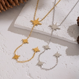 Elegante Y-Halsketten mit Stern-Quasten in Gold und Silber auf strukturiertem Hintergrund