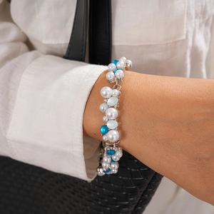 Detail of beaded necklace with white pearls, blue and green resin beads on silver base