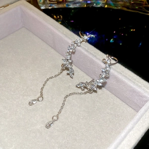 Close-up of silver tassel earrings with marquise-cut zircons on a jewelry tray