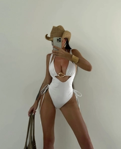White cutout monokini with gold buckle detail and side tie strings for beach holiday