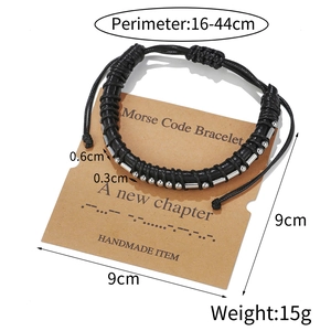 Handmade Morse code bracelet with black cord and silver beads on a display card