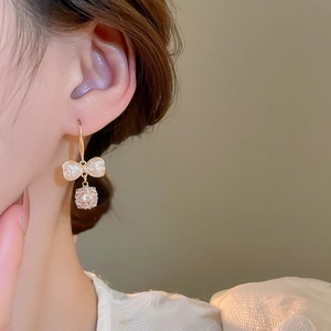 Detail of elegant bow and faceted crystal ball drop earring on model ear side view