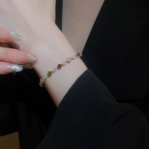 Close-up of a delicate silver bracelet with colorful zircons worn on a wrist