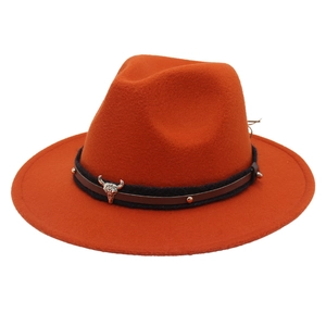 Detail of orange wool fedora featuring dual decorative leather bands and silver bull head