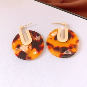 Detail view of 18K gold plated hoop earrings with round tortoiseshell acetate pendants