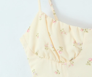 Detailed close-up of yellow floral sundress with gathered bust and thin straps