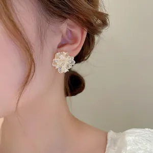 Elegant white floral stud earrings with sparkling diamonds on a model for a sweet look