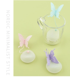 Detailed view of colorful butterfly-shaped silicone tea infusers on a Nordic minimalist background
