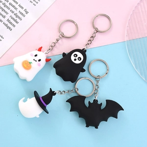 Cartoon Halloween keychains featuring pumpkin ghost and bat figures on a pastel backdrop