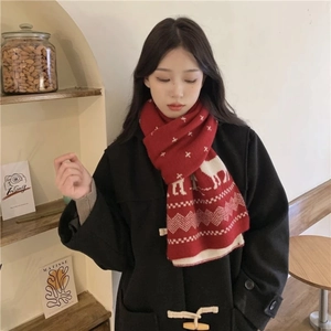 Detail of red knitted scarf with white elk pattern and geometric nordic design