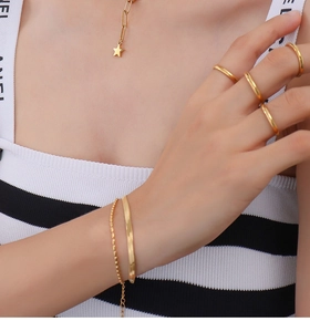 Detailed view of 18k gold plated star necklace, sleek rings and snake chain bracelet set