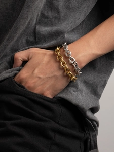 Wrist shot of gold and silver four-leaf clover bracelets on stainless steel chain