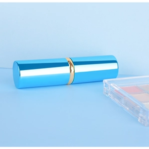 Gros plan du pinceau poudre rétractable bleu avec boîtier métallique et bague dorée