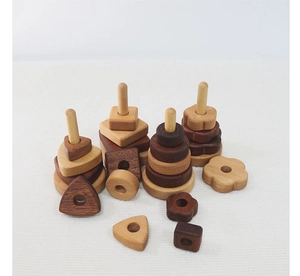 Detailed view of four natural wood geometric stacking bases with smooth shapes