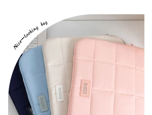 Quilted laptop sleeve details in navy, blue, cream, and pink with grid stitching texture