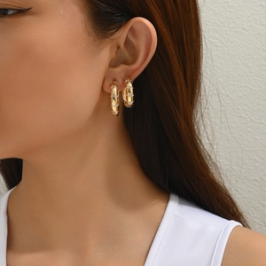 Gros plan de boucles d'oreilles en C plaquées or 18 carats avec diamants sur un modèle