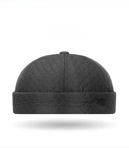 Detail of dark grey quilted brimless docker hat with diamond stitch and sports label