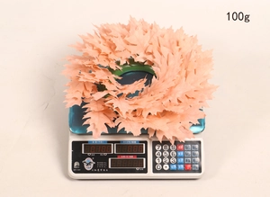 Detail view of 100g orange artificial maple leaf bundle on an electronic scale