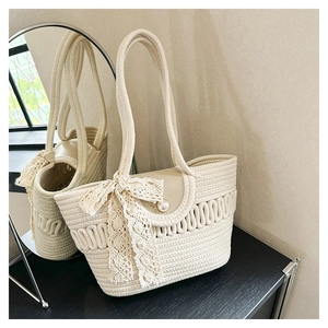 Detailed macro view of woven cream tote bag with lace bow and elegant pearl button