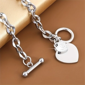 Polished stainless steel OT buckle bracelet with silver heart charms and zircon stones