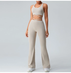 Detail view of beige racerback sports bra with cross-waist ties and flared yoga pants