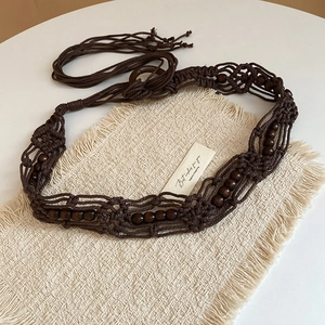 Bohemian handmade macrame waist belt with dark wooden beads and tassel on white background