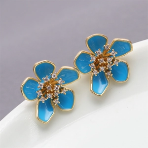 Detailed view of blue floral stud earrings with gold plating and zircon inlay stones