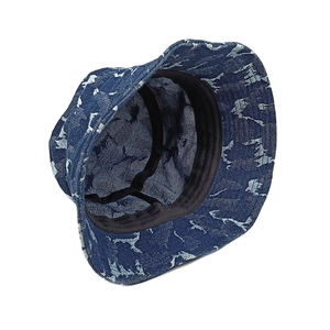Detail view of washed denim bucket hat with white horse prints and black lining