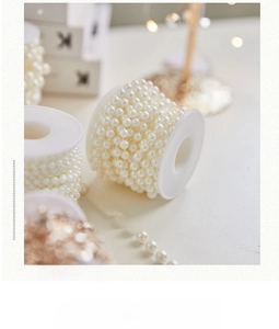 Detailed macro view of cream faux pearl bead strand on a spool for Christmas DIY crafts