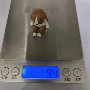 Miniature resin French Bulldog figurine weighing 9.4g on a digital scale measurement