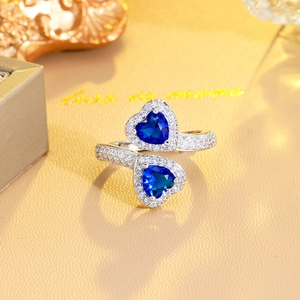 Adjustable silver ring with two heart-shaped blue sapphires and micro-pave crystals