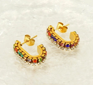 Detailed close-up of luxurious U-shaped gold earrings with colorful multi-gemstone inlay