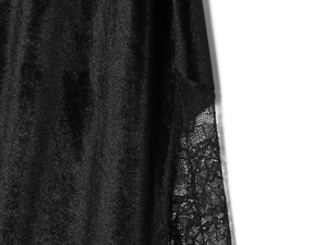 Détail montrant la texture velours noir élégante et les coutures en dentelle sur la robe