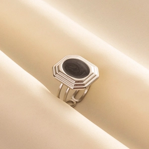 Detail of vintage 304 stainless steel ring with black marble inlay on silk fabric