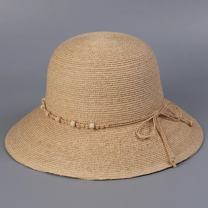 Detail eines Raffia-Sonnenhuts mit handgewebter Textur, Holzperlen und einer Schleife